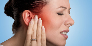 sick female having ear pain touching her painful head